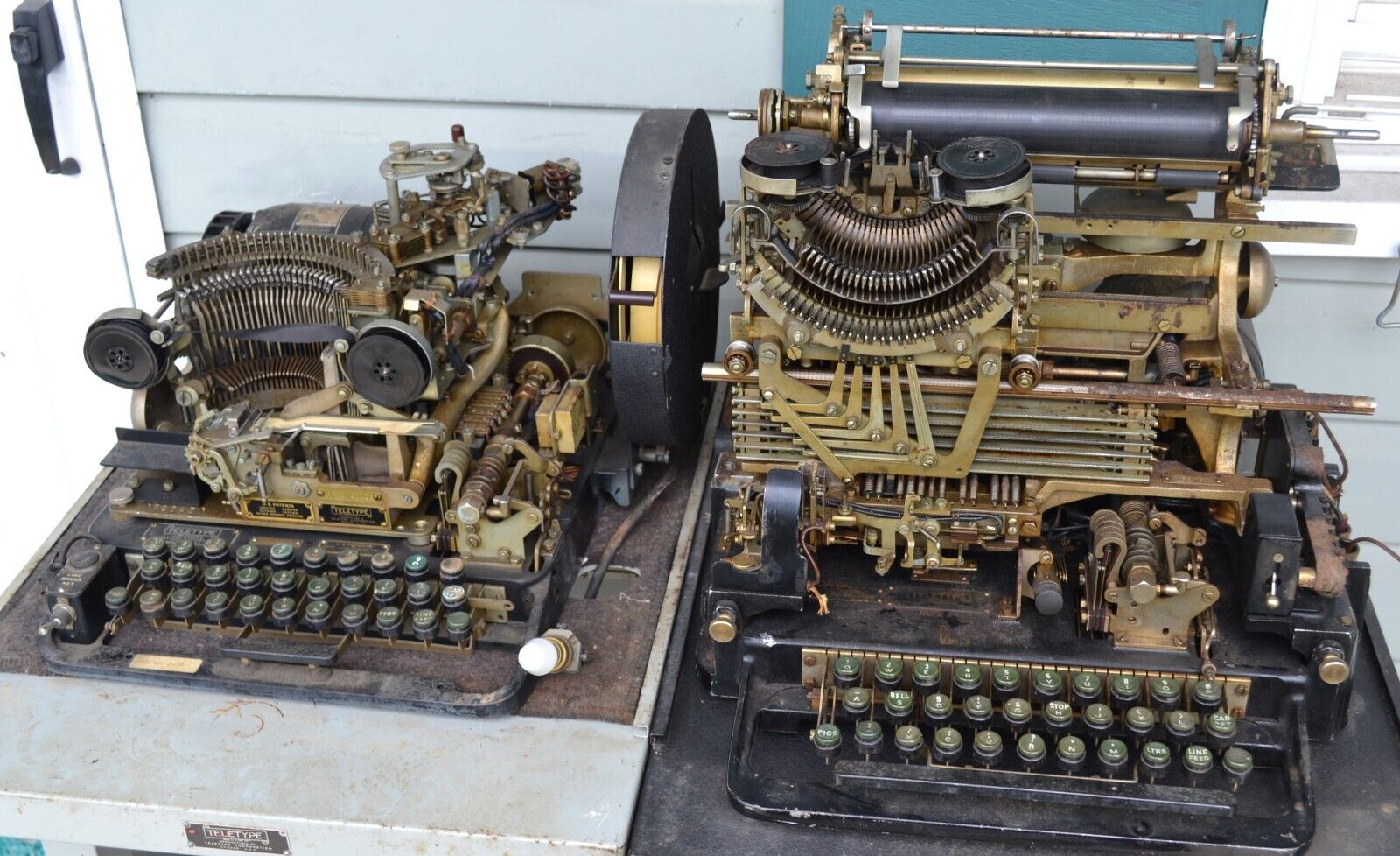 TWO VINTAGE WWII ERA TELETYPE MACHINES WITH ORIGINAL MANUALS & TABLES